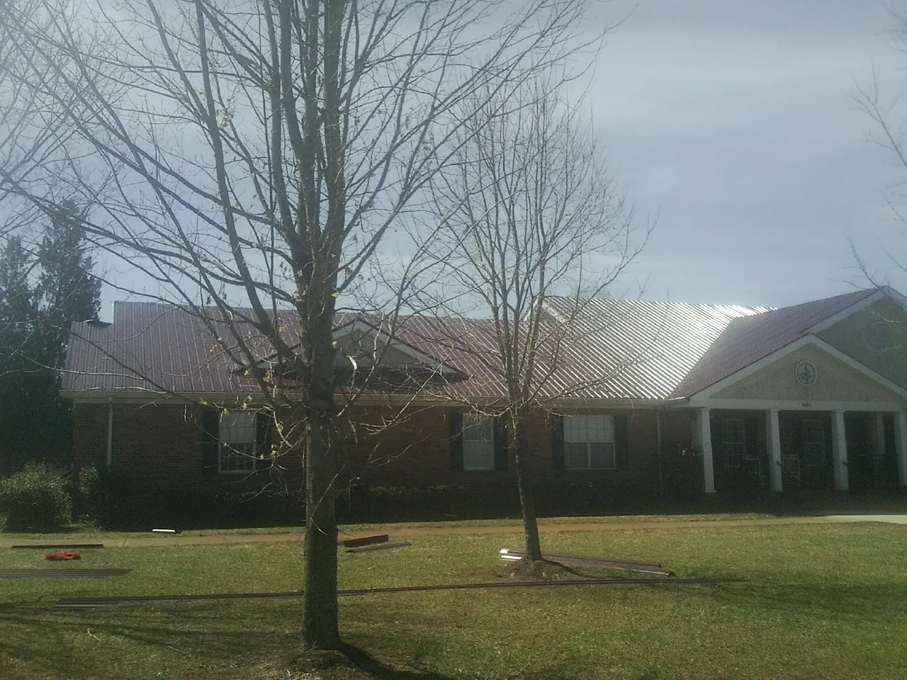 Red metal roof on a brick building seen from the front lawn in Millersburg